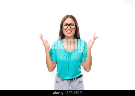 young confused brunette european lady with straight hair dressed in casual clothes wears glasses for vision Stock Photo