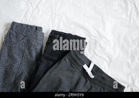 three pairs of women's pants lie on a white background close up Stock Photo