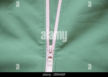 light green jacket with pink zipper as background close up Stock Photo