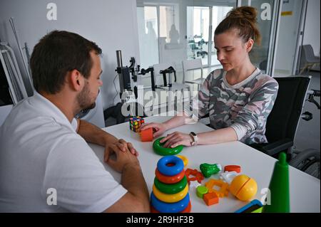 Non Exclusive: LVIV, UKRAINE - JUNE 23, 2023 - A patient exercises under the supervision of an occupational therapist at the UNBROKEN National Rehabil Stock Photo