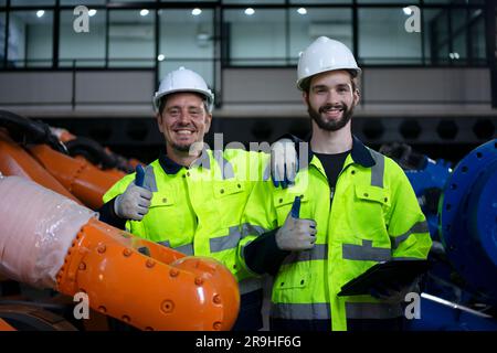 Engineer work at robotic arm factory. Technology and engineering concept. Stock Photo