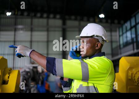 Engineer work at robotic arm factory. Technology and engineering concept. Stock Photo