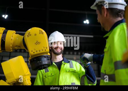 Engineer work at robotic arm factory. Technology and engineering concept. Stock Photo