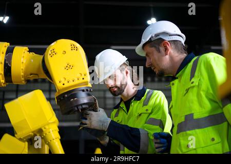 Engineer work at robotic arm factory. Technology and engineering concept. Stock Photo