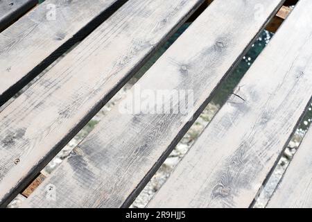 Wooden platform over sea water. Old wood boards texture background and surface of sea or ocean. Pedestrian bridge. Stock Photo