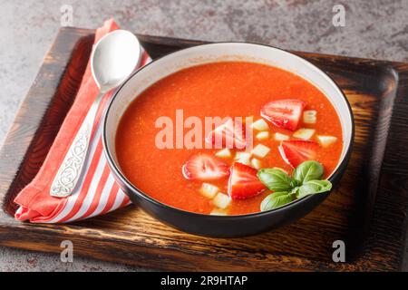 Tomato and strawberry gazpacho soup on a wooden board close-up on the table. Horizontal Stock Photo