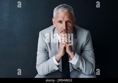Serious portrait of senior attorney sitting with confidence, mockup space and dark background in studio. Pride, professional career ceo and executive Stock Photo