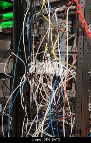 Messy tangled electric cables connecting to industrial lab devices on a rack, no people Stock Photo