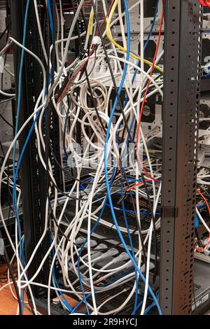 Messy tangled electric cables connecting to industrial lab devices on a rack, no people Stock Photo