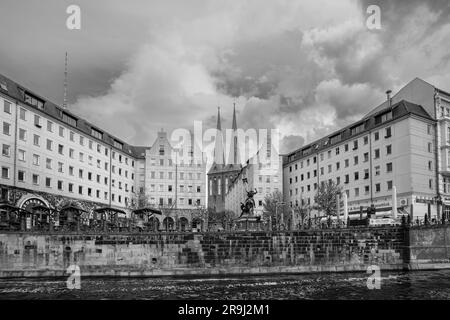 Berlin, Germany - April 19, 2023 : View of the statue Saint George the Dragon slayer, residential buildings and the Nikolai Church in the background Stock Photo