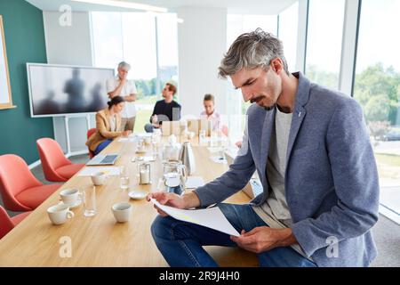 Male professional reading report in conference room at office Stock Photo
