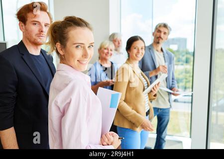 Portrait of smiling business team standing together in office Stock Photo