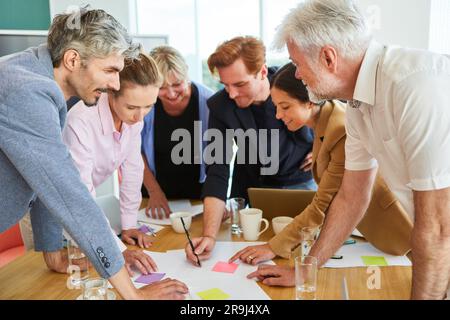 Confident team of business professionals discussing over documents Stock Photo
