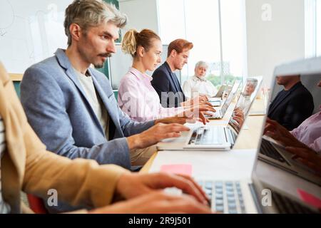 Dedicated male and female executives using laptops at workplace Stock Photo