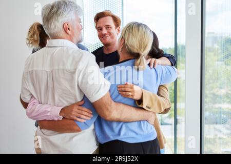 Smiling businessman huddling together with team during meeting Stock Photo