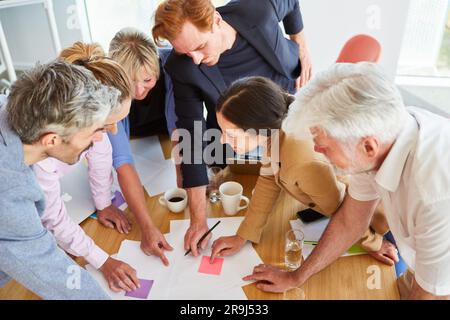 Team of business professionals discussing over documents in meeting Stock Photo
