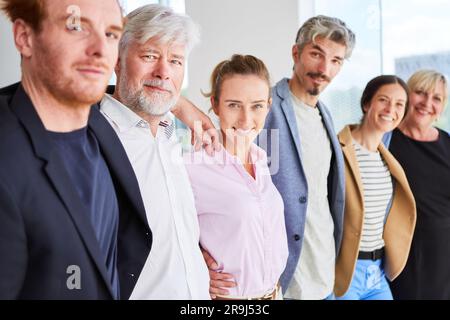 Row of happy business people standing together in the office Stock Photo