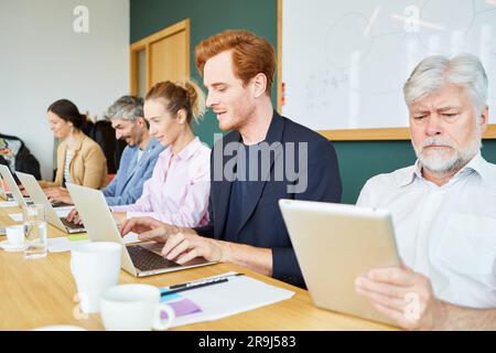 Team of business executives using laptops and tablet PC in office Stock Photo