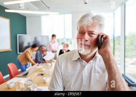 Portrait of bearded senior businessman talking on smart phone Stock Photo