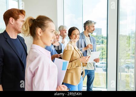 Smiling businesswoman standing with male and female colleagues Stock Photo