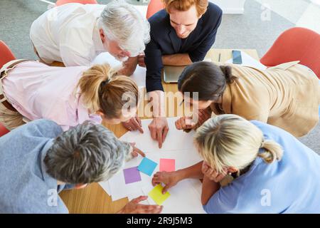 Business professionals discussing over documents and sticky notes Stock Photo