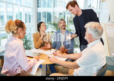 Confident businessman discussing with male and female colleagues Stock Photo