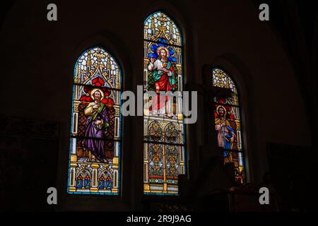 A dimly lit building interior filled with colorful stained glass windows Stock Photo