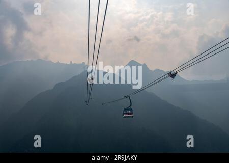 Sa Pa, Vietnam-April 2023; Panoramic view from a cable car leading to the top of Fanxipan Mountain during stormy weather with dark clouds and mist Stock Photo