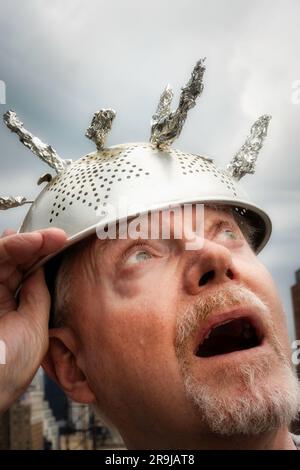 Man wearing tinfoil hat due to the superstition of extraterrestrial activity and paranormal occurrences, 2023, United States Stock Photo