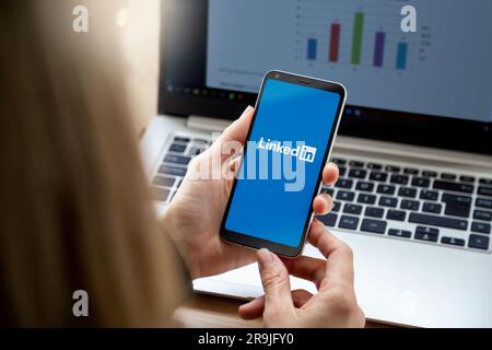 LinkedIn app on smartphone screen. woman holding a phone with a professional and business oriented social network service application. ROSARIO, ARGENT Stock Photo