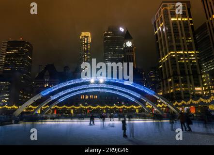 Nathan Phillips Civic Square People skating at the public skating rink in front of City Hall. Winter Holiday Events. TORONTO, ONTARIO Stock Photo