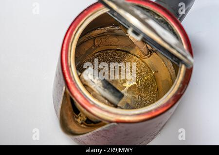 An old electric kettle with traces of scale and limescale on the walls and bottom. What happens to unfiltered water during boiling. Calcium-magnesium Stock Photo