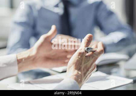 Two business men sit at desk discuss project details Stock Photo