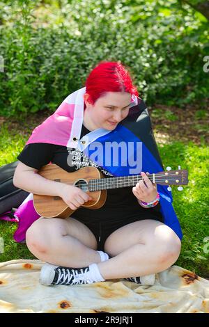 Teens Against Genital Mutilation rally, Hyannis, MA, USA (Cape Cod). Celebrating pride.  Playing a guitar Stock Photo