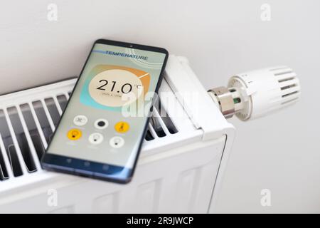 Smart Home: Man Controlling Heating Using App Stock Photo