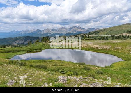 Summer Mountain Pond -  A panorama of a small pond at summit of Cottonwood Pass, surrounded by high peaks of Sawatch Range, on a calm Summer day. Stock Photo