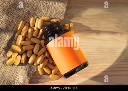 A container for pills, pills spilling out of a bottle. A natural medicine. Mockup, empty label. Stock Photo