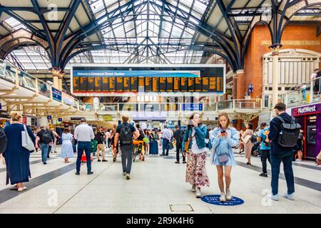 Large electronic departure screen at Liverpool Street Station in London, UK. The station is busy with passengers. Stock Photo