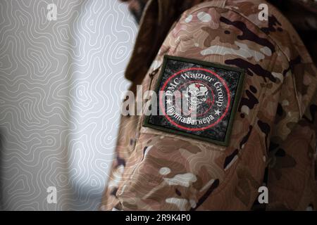 Wagner Group Soldier. Soldier with flag Wagner Private Military Company, PMC Wagner flag on a military uniform. Camouflage clothing Stock Photo