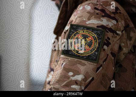 Wagner Group Soldier. Soldier with flag Wagner Private Military Company, PMC Wagner flag on a military uniform. Camouflage clothing Stock Photo