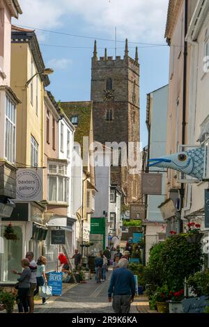 Shops in historic buildings along alleyway with tower of church of St Saviour, Foss Street, Dartmouth, Devon, England, UK Stock Photo