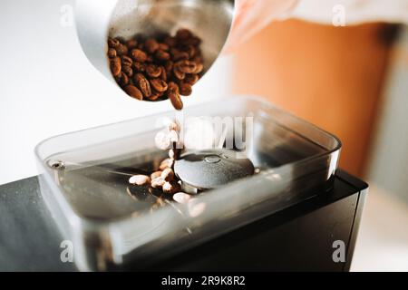 Unrecognizable young man preparing coffee in. Close up of coffee beans. Stock Photo