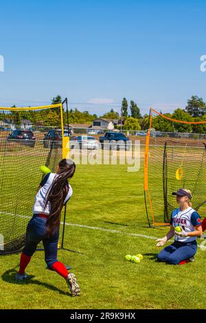 Batting practice before a girls Fastball game on Vancouver Island Canada Stock Photo