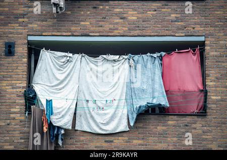 Laundry hung up to dry on clothes lines strung across the balconies of an apartment building in the Netherlands Stock Photo