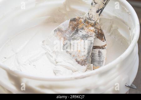 Working with sparkle wall compound spatula human hand construction interior renovation Stock Photo