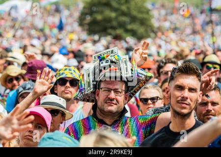 Fans (many already in Elton John outfits incl Alex McGuire and his Elton tribute pyramid stage model hat) watch as Sophie Ellis-Bexter plays the Pyramid stage and includes a song as tribute to her husband, guitar player, as it is their wedding anniversary - unday at the 2023 Glastonbury Festival, Worthy Farm, Glastonbury. Stock Photo