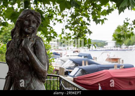 Henley-on-Thames, Oxfordshire, Uk. 27th June, 2023. The Thames Mermaid statue by th River Thames in Henley keeps a watchful eye on the rowers. Credit: Maureen McLean/Alamy Live News Stock Photo