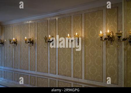 Vintage golden wallpaper with pattern. Sconce fixture lighting Stock Photo