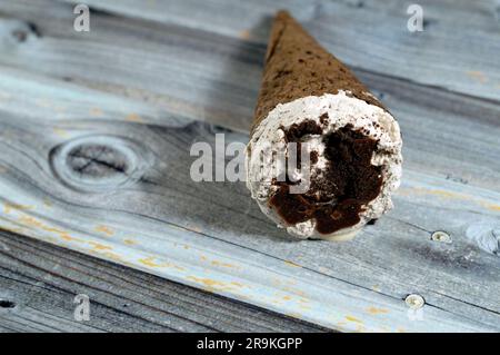 Ice cream of cocoa chocolate and vanilla cone with topping of chocolate chips cookies pieces in crispy wafer cones, melting cold ice cream twirl with Stock Photo