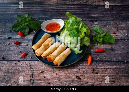 Tasted and fresh oriental food : Nems on a plate with sauce and tasty fresh mint leaves Stock Photo